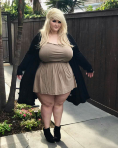Full figured large breasted blonde in simple brown dress.