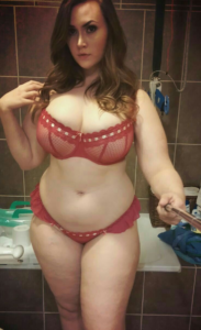 Curvy amateur bathroom selfie wearing sheer red bra and panties.